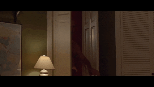 a shirtless man is standing in a closet next to a lamp and a map