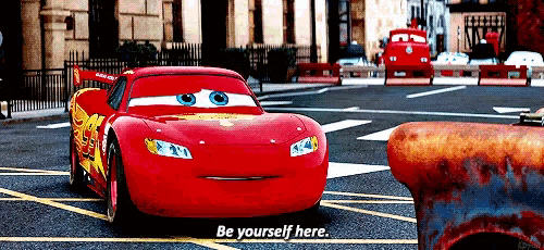 lightning mcqueen from cars is driving down the street and says " be yourself here "