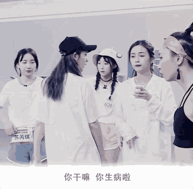 a girl wearing a white shirt that says 101 stands between two other girls