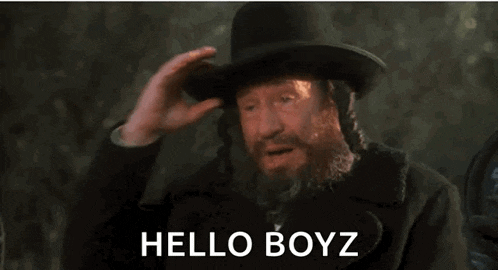 a man with a beard is wearing a top hat and saying hello boyz .