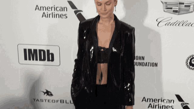a woman stands on a red carpet in front of an imdb logo