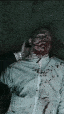 a man is laying on the ground with blood coming out of his face