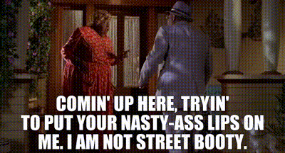 a man and a woman are standing next to each other in front of a door and talking .