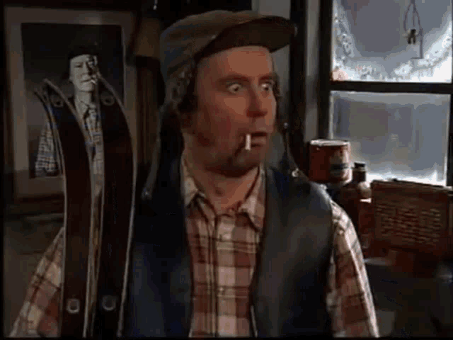 a man in a plaid shirt is smoking a cigarette and holding skis .