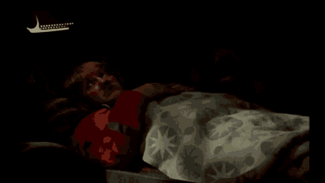 a man laying in bed with a blanket that says g ' natt on it