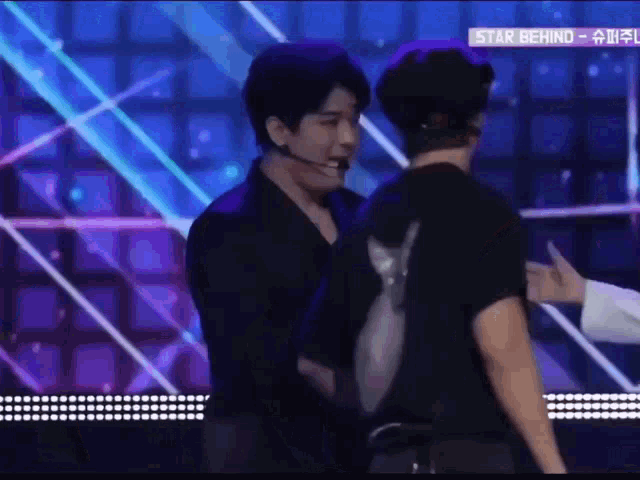 a man in a black shirt is standing next to another man in a black shirt .