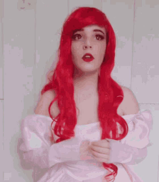 a woman with red hair is wearing a pink off the shoulder dress
