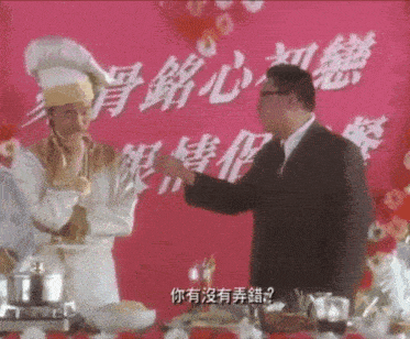 a man in a chef 's hat is talking to a man in a suit