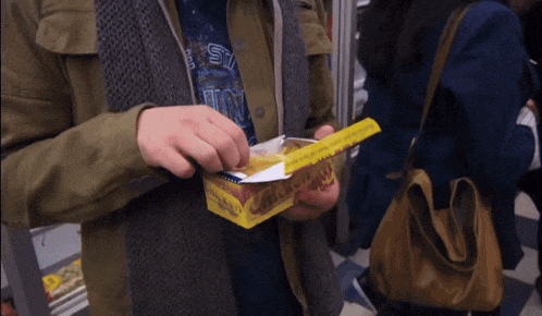 a man wearing a shirt that says ' st ' on it is opening a box