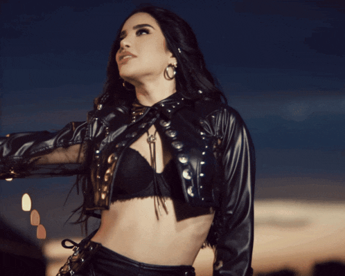 a woman wearing a black leather jacket and a bra