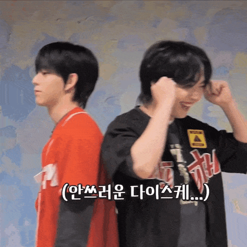 two boys are standing back to back with one wearing a t-shirt that says ' caution ' on it