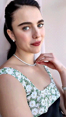 a woman wearing a black and white floral dress and a necklace