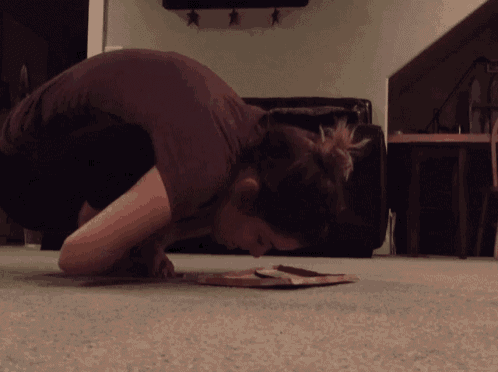 a woman crawling on the floor with her head on a piece of paper