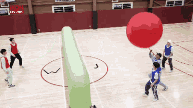 a group of people are playing a game of dodgeball on a court that says icon on air in the background