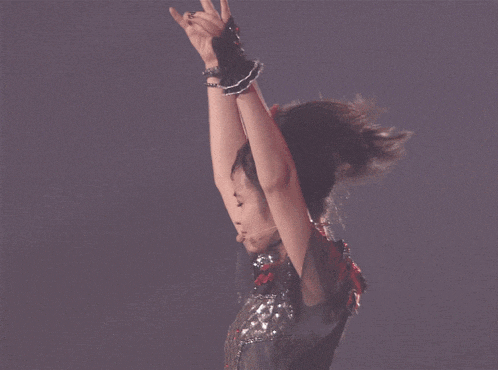 a woman with her arms in the air wearing chains