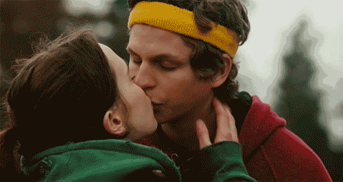 a man wearing a yellow headband is kissing a woman