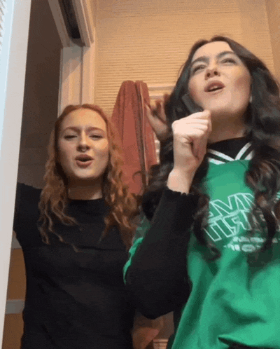 a woman wearing a green sweatshirt that says ucsd on it