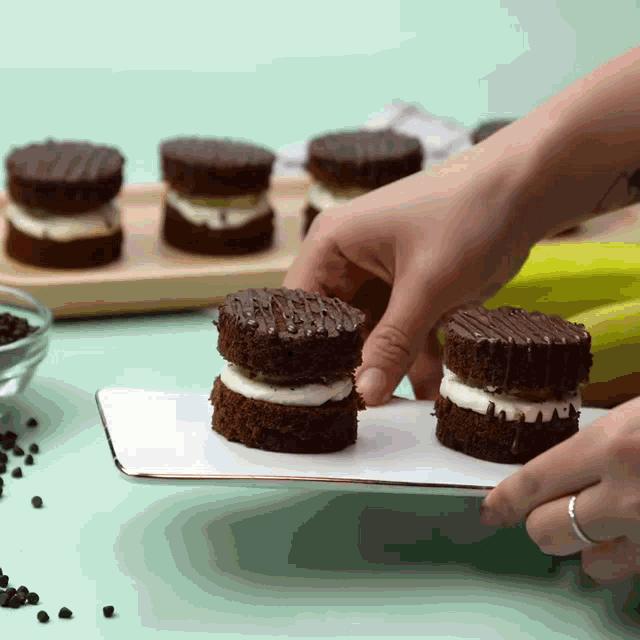 a person is holding a white plate with a few cakes on it