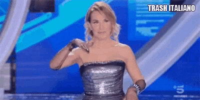 a woman in a strapless dress is standing on a stage with trash italiano written on the bottom of the screen