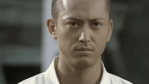 a man with a shaved head is looking at the camera