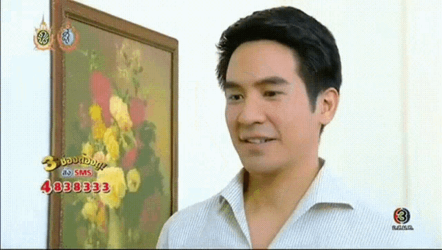 a man stands in front of a framed picture with the number 4038333 on the bottom right