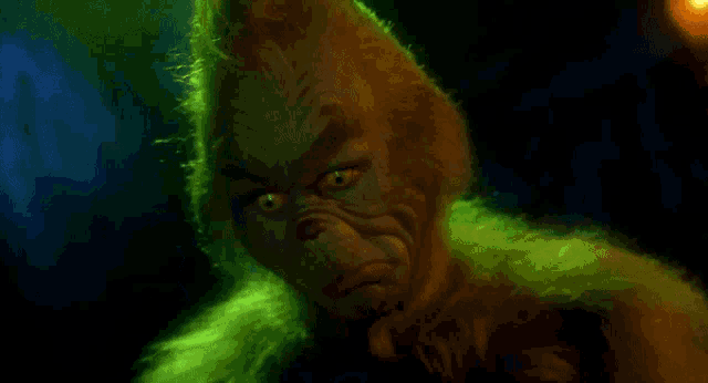 a close up of a person 's face in a dark room with green lights behind them .