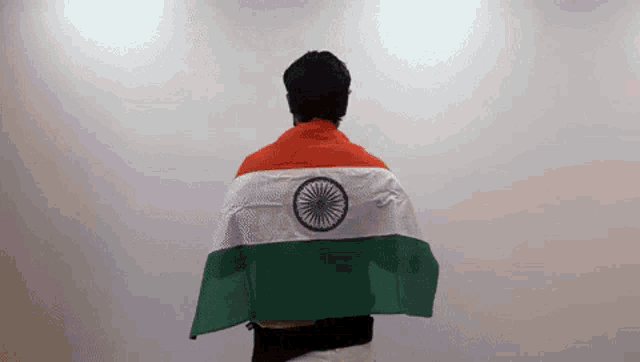 a man is holding an indian flag draped over his shoulders