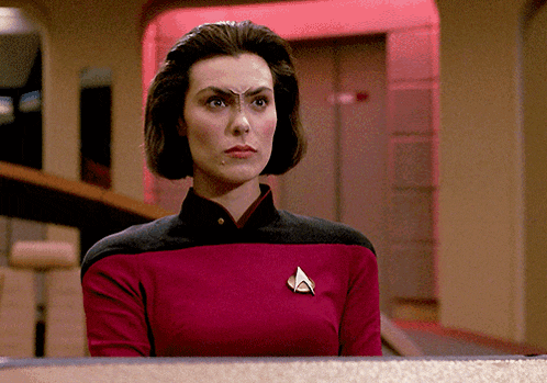 a woman in a star trek uniform has a badge on her chest that says a