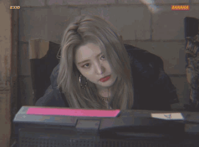 a woman is sitting in front of a laptop with the word banana on the bottom