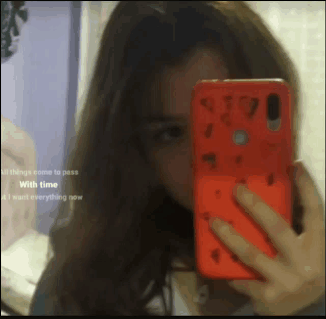 a girl taking a selfie with a red phone that says ' all things come to pass with time ' on it