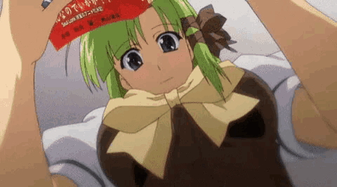 a girl with green hair is laying on a bed with a red sticker on her head that says ' tokyo ' on it