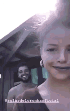 a man and a woman are standing next to each other smiling .