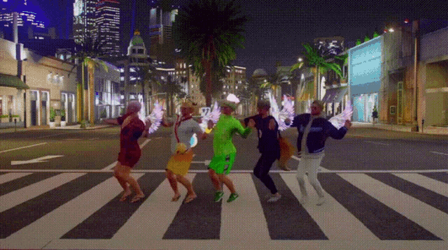 a group of people are dancing on a street at night
