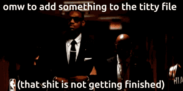 a man in a suit and tie stands in a dark room with a caption that says omw to add something to the titty file