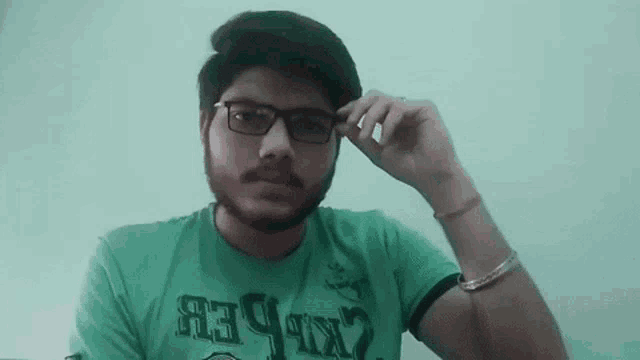 a man with a beard wearing glasses and a green shirt that says ' army ' on it