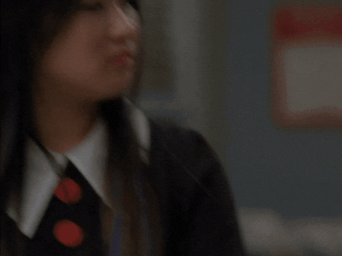 a blurry picture of a woman wearing a black jacket and white collar
