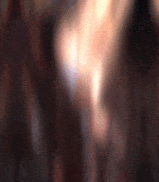 a blurry picture of a person 's face with a candle in the foreground