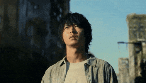 a man in a grey shirt is looking up into the sky