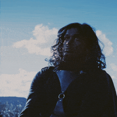 a man with long hair and a ring around his neck
