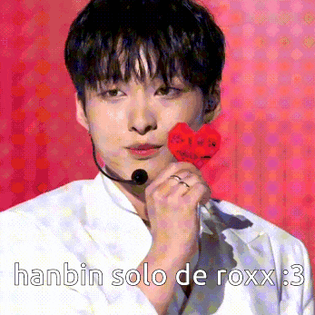 a man holding a red heart with the words hanbin solo de roxx