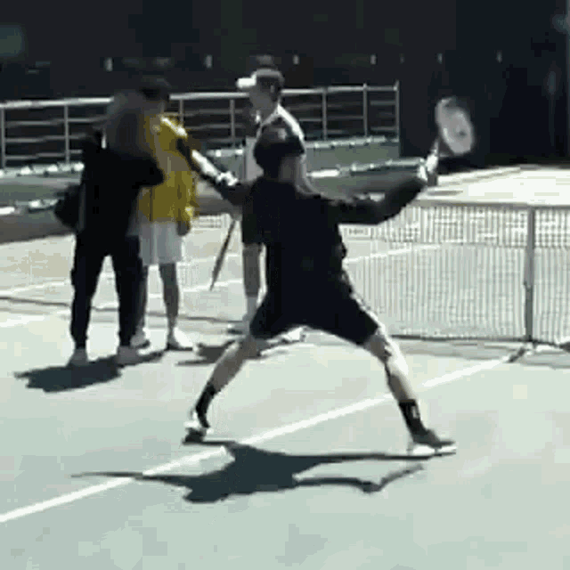 a group of people playing tennis on a court