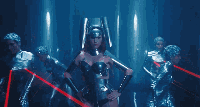 a group of people are standing in a dark room with red lights