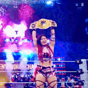 a woman is holding a wrestling championship belt over her head .