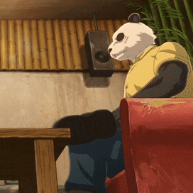 a panda bear in a yellow shirt is sitting in a red chair
