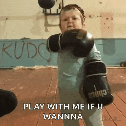 a little boy wearing boxing gloves says play with me if u wanna