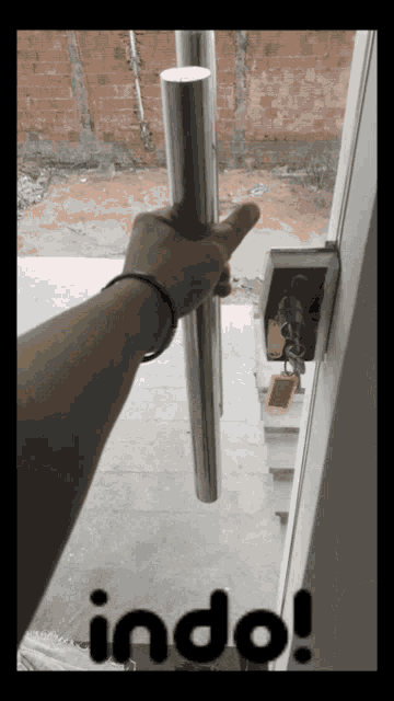 a picture of a person holding a door handle with the word indo on the bottom right