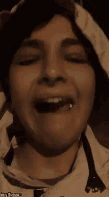 a close up of a person 's face with their mouth open and teeth visible .