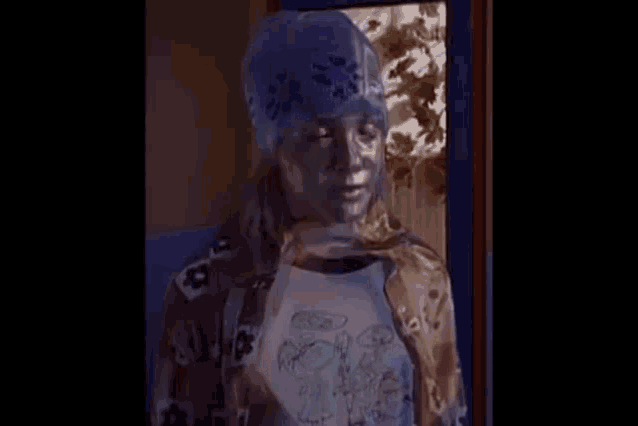 a young girl wearing a blue beanie and a plaid shirt is standing in front of a door .