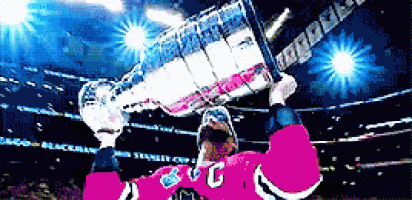 a hockey player in a pink jersey with the letter g on it holds up a trophy