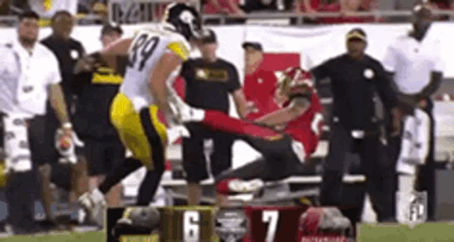 a football player is kicking another player in the leg during a game .